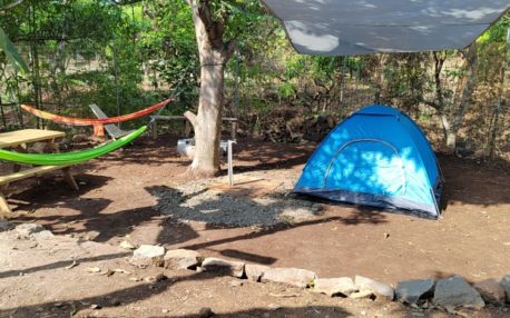 Flat area outdoors with tent and hammocks